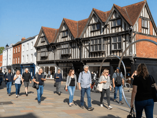 Visitors exploring the historic street of Cross Cheaping Coventry on a sunny day.