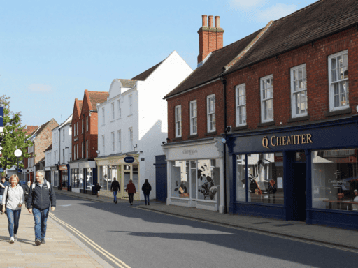 A photo of Trinity Street Coventry with pedestrians walking near shops.